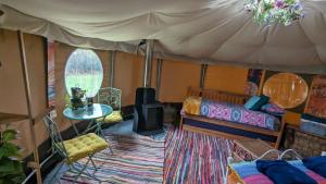 a room with a tent with a bed and a rug at Cosy Glamping Yurt with log burner on our smallholding, ideal family getaway or romantic retreat in Narberth