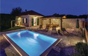 a swimming pool in a yard with a table and chairs at Holiday Home Sicici Iv in Puljane