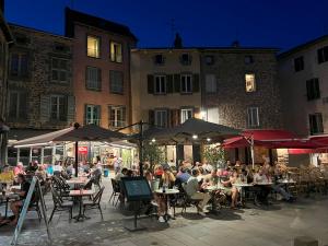 a group of people sitting at tables in front of a building at Artist Flat Saint Flour in Saint-Flour