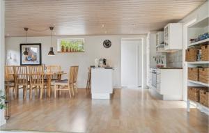 a kitchen and dining room with a table and chairs at Beautiful Home In Væggerløse With Wifi in Marielyst