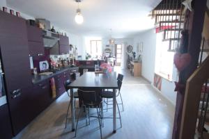 a kitchen with a table and chairs in a room at Appartement 90 m2 in Vic-sur-Seille