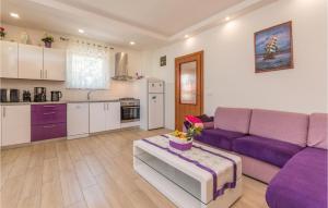 a living room with a purple couch and a kitchen at Holiday Home Zadar 37 in Kakma