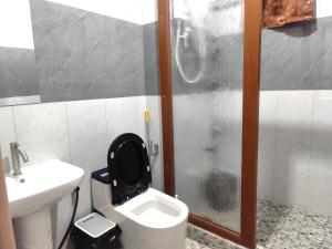 a bathroom with a toilet and a sink and a shower at TripleG's Transient Apartment House with FREE PARKING and CCTV in La Trinidad