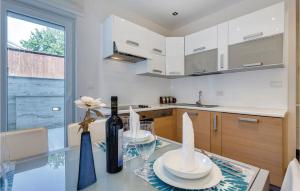 een keuken met een glazen tafel en een fles wijn bij Gorgeous Apartment In Crikvenica in Crikvenica