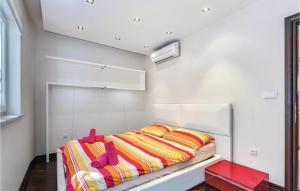 een kleine slaapkamer met een bed met kleurrijke dekens bij Gorgeous Apartment In Crikvenica in Crikvenica