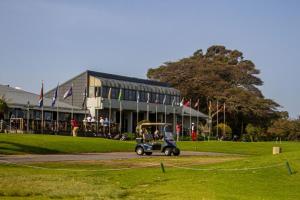 un carro de golf estacionado frente a un edificio en Mill Park Garden Cottage, en Gqeberha