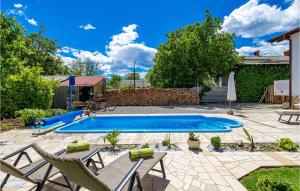 una piscina in un cortile con sedie e un patio di Cozy Apartment In Drazice With Wifi a Dražice