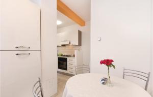 a white kitchen with a table with a flower on it at Apartment Fazana 09 in Fažana