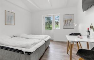 a white room with a bed and a table at 1 Bedroom Amazing Apartment In Svaneke in Svaneke