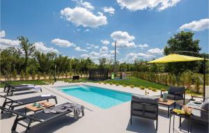 a swimming pool with two chairs and an umbrella at Villa Le in Šibenik