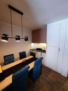 a room with a table and chairs and a kitchen at Apartman Radmila in Kopaonik