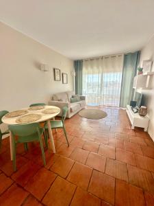 a living room with a table and chairs and a couch at Solar Home appartement T2 in Albufeira