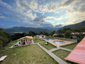 a resort with a pool and mountains in the background at Finca Turística El Porvenir in Cáqueza