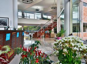Un vestíbulo con flores y escaleras en un edificio en Hotel Chácara do Mosteiro, en São Vicente