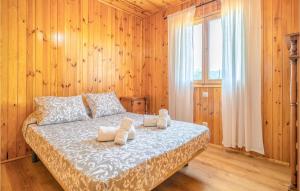a bedroom with a bed with wooden walls and a window at Amazing Home In El Borge With Wifi in Moclinejo