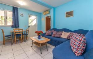 a living room with a blue couch and a table at 1 Bedroom Awesome Apartment In Turanj in Turanj