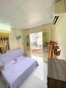 a bedroom with a purple bed and a table at Lavie House HCM - 2 Bedrooms House- Near Bui Vien street in Ho Chi Minh City