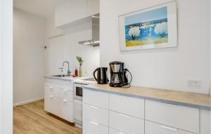 a kitchen with white cabinets and a counter top at Lovely Apartment In Svaneke With Wifi in Svaneke