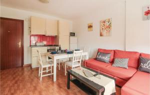 a living room with a red couch and a table at Pet Friendly Apartment In Torremolinos in Torremolinos