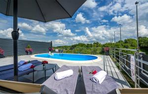 un patio avec deux chaises et un parasol à côté d'une piscine dans l'établissement Gorgeous Home In Varazdin Breg, à Varaždin Breg 43 autres photos