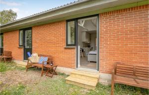 a brick house with a bench and a patio at Stunning Apartment In Svaneke With Wifi in Svaneke