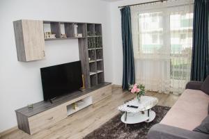 a living room with a tv and a couch and a table at Apartament Rubin in Sibiu