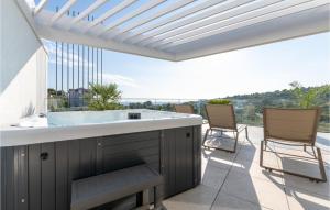 einen Whirlpool auf einer Terrasse mit Stühlen in der Unterkunft 4 Bedroom Stunning Home In Murter in Murter
