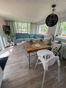 un salon avec une table et un canapé dans l'établissement Luxe groot chalet voor 6 personen op de Veluwe!, à Doornspijk