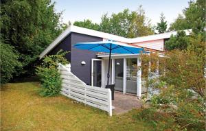 a house with a blue umbrella in front of it at Holiday Home Klydevej Ørsted Ix in Kare
