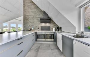 eine Küche mit weißen Schränken und einer Ziegelwand in der Unterkunft 8 Bedroom Amazing Home In Ringkøbing in Ringkøbing