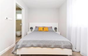 ein weißes Schlafzimmer mit einem großen Bett und gelben Kissen in der Unterkunft Five-Bedroom Holiday Home In Kastel Kambelovac in Kaštela