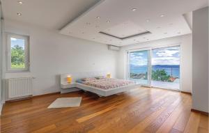 a white bedroom with a bed and a large window at Holiday Home Sopaljska Cr in Crikvenica