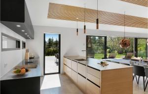 a kitchen with a large island and a dining room at Lovely Home In Græsted With Sauna in Græsted
