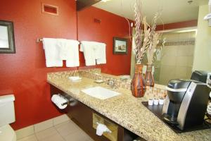 a bathroom with a sink and a red wall at Pahrump Nugget Hotel & Casino in Pahrump