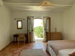 a bedroom with a bed and a desk and a window at La canopée, Bastide sur les hauteurs de Lourmarin in Lourmarin
