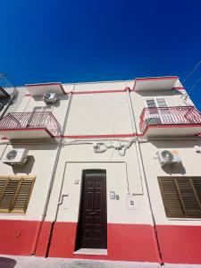 un edificio rosso e bianco con una porta di La Rosa di Candy a Brindisi