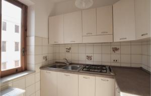 a kitchen with white cabinets and a sink and a window at Cozy Apartment In Nocera Terinese in Nocera Terinese