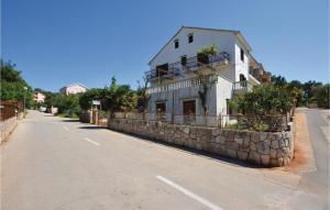 a white building on the side of a road at One-Bedroom Apartment In Vrboska in Vrboska