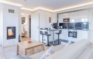 Una sala de estar con un sofá blanco y una cocina. en Sky Suite Eden, en Binz