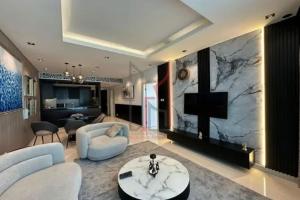 a living room with white furniture and a marble wall at 1br - 5 min from Burj Khalifa and Mall - Best view in Dubai