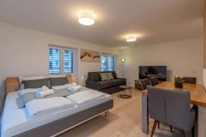 una camera da letto con un letto grande e un soggiorno di Jasminkas Host 2, Ruhig, City und Naturnah, Gratis Parkplatz und Balkon a St. Gallen