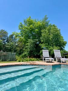 two chairs sitting next to a swimming pool at Los Narcisos in San Antonio de Areco