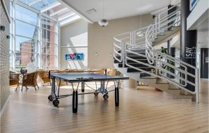 Una mesa de ping pong en una habitación con una escalera de caracol. en Fanø Bad, Værelse 26, en Fanø