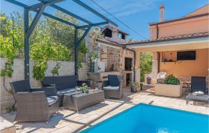 a patio with a pool and chairs and a house at 1 Bedroom Lovely Apartment In Brodarica in Brodarica