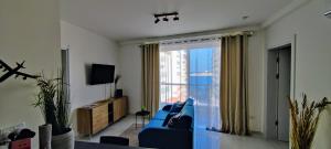a living room with a blue couch and a large window at Seaview Three-O-Two in St. Paul's Bay