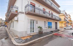 ein weißes Gebäude mit einem Balkon an einer Straße in der Unterkunft Gorgeous Apartment In Balestrate in Balestrate