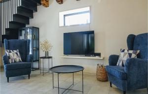 a living room with two blue chairs and a flat screen tv at Villa Pepa in Zarečje
