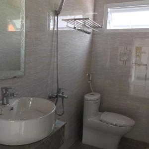 a bathroom with a white sink and a toilet at MIA Villa Đà Lạt in Khu Chi Lăng +18 photos