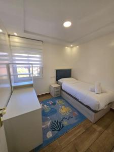 Un dormitorio pequeño con una cama y una alfombra. en Alojamiento Entero Moderno En Barcelona Terrassa, en Terrassa