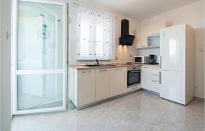 a kitchen with a white refrigerator and a sink at Stunning Apartment In Labin With House Sea View in Labin
